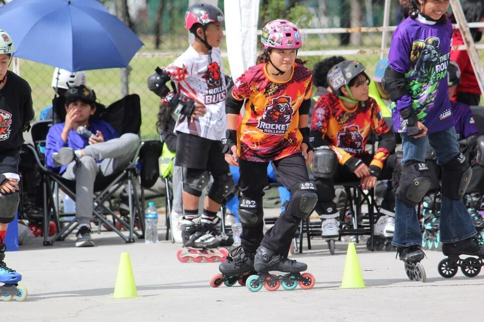 Patinadores con sus protecciones se preparan en la pista.