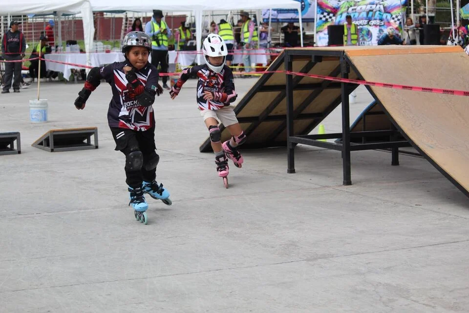 Dos patinadores recorren juntos un circuito de obstáculos.